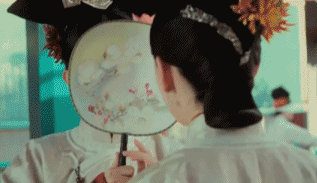 用扇子掩脸逗乐的女人
