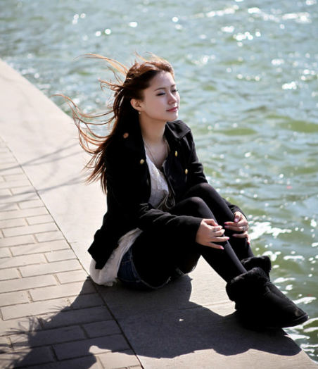 坐在湖边吹风的美女