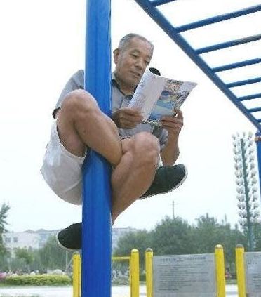 牛人盘在钢管上看书