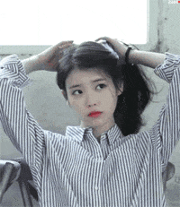 对着镜子扎头发的可爱妹子