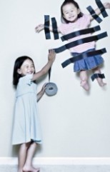 调皮的小孩把妹妹粘到墙上