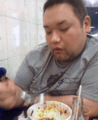 扭扭捏捏吃饭的胖男子